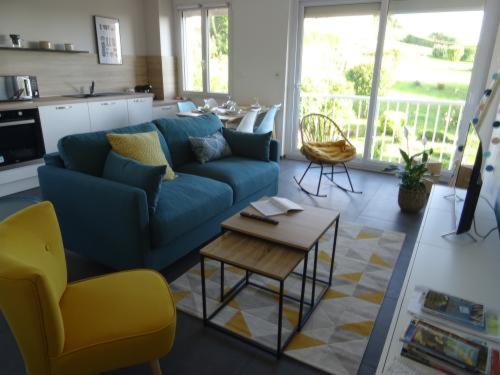 a living room with a blue couch and a table at Côte et Mer in Le Portel