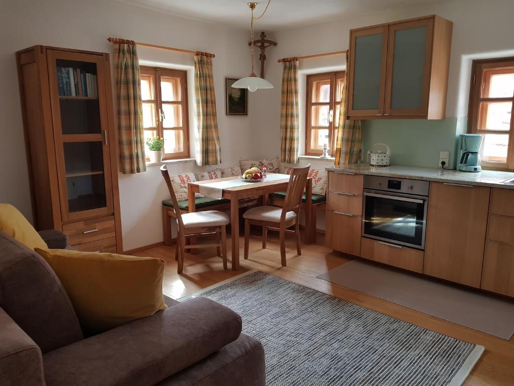 a kitchen and living room with a table and chairs at Ferienappartement am Leisnitzbach in Tamsweg