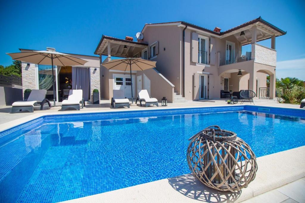 a villa with a swimming pool in front of a house at Villa Franka in Labin