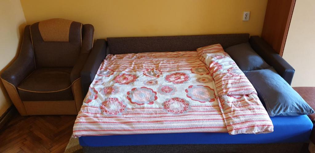 ein Bett mit einer Decke darüber in der Unterkunft Citadel Park Apartment in Sighişoara