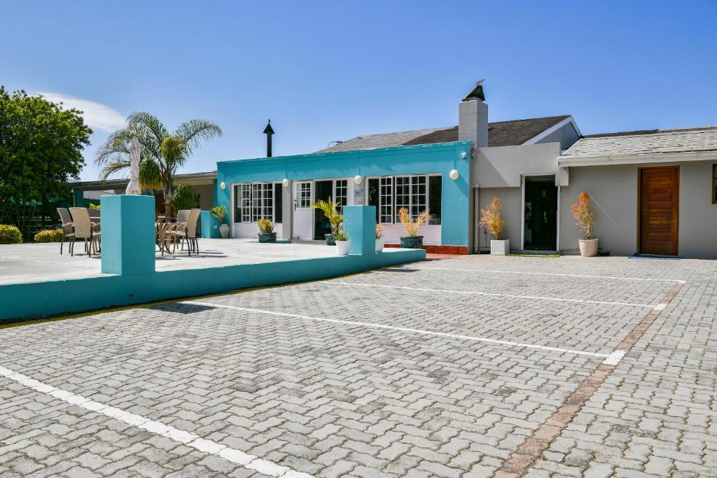 a blue and white building with a patio at AL-BEIT LODGE in Port Elizabeth