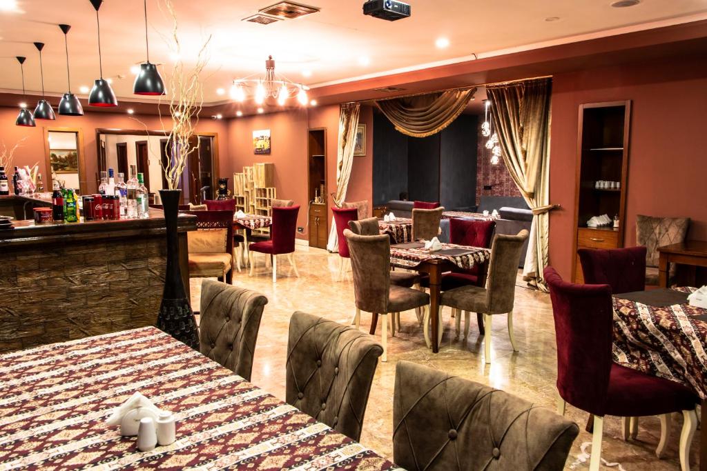 a restaurant with tables and chairs and a bar at Atropat Old City Hotel in Baku