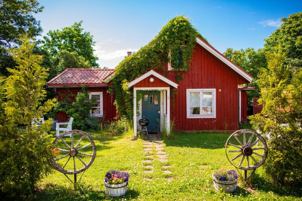 a red house with two wagon wheels in front of it at Westergårds in Föglö