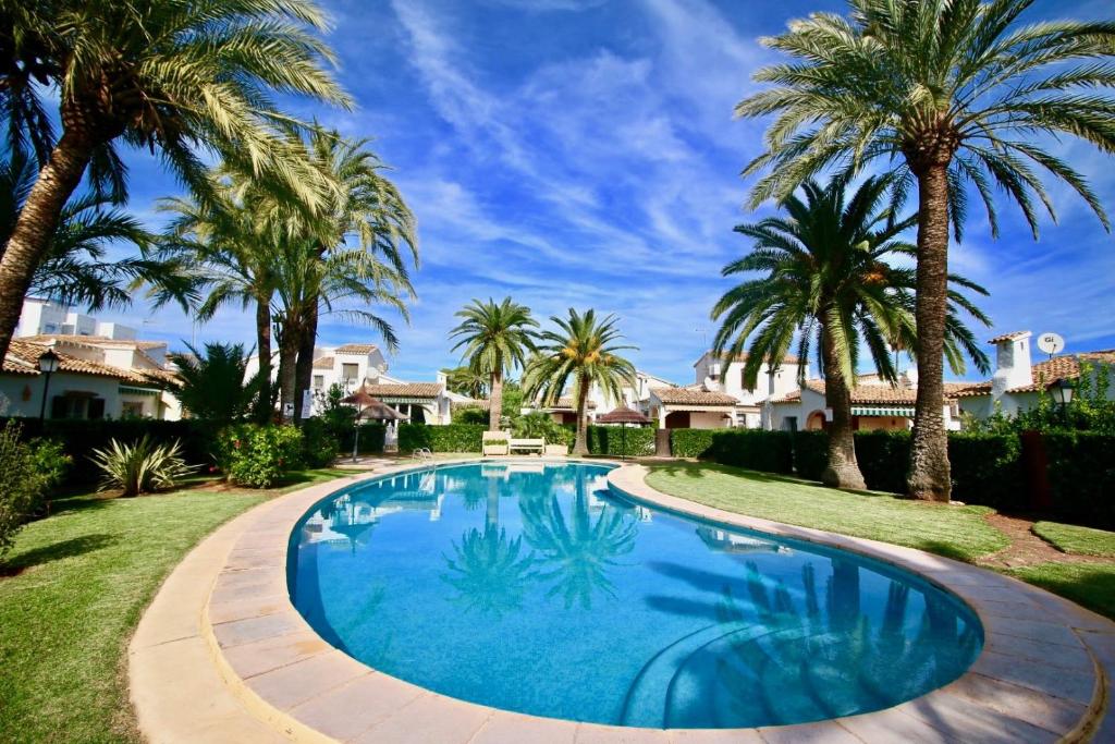 una piscina en un patio con palmeras en Puerto Azul 5 en Dénia