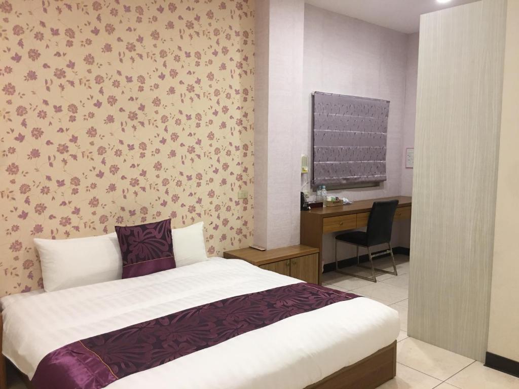 - une chambre avec un lit et un bureau avec un ordinateur dans l'établissement Rural Area Hotel, à Wanqiao