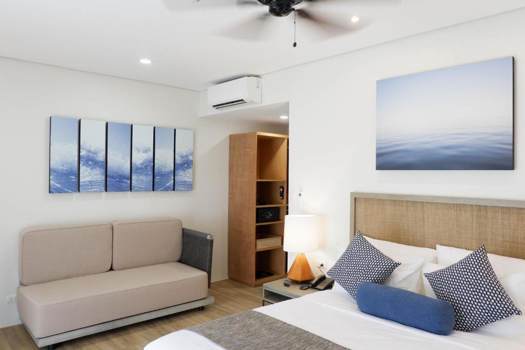 ein Schlafzimmer mit einem Bett, einem Stuhl und Gemälden in der Unterkunft Huni Lio in El Nido