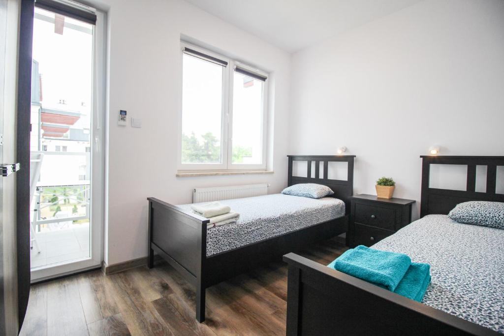 dwa łóżka w pokoju z dwoma oknami w obiekcie Apartament Lublin Stare Miasto "Wild Cat" w mieście Lublin