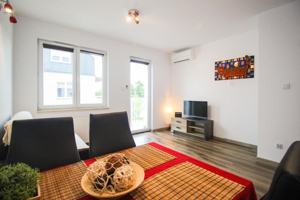 un soggiorno con tavolo, sedie e TV di Apartament Lublin Stare Miasto "Wild Cat" a Lublino