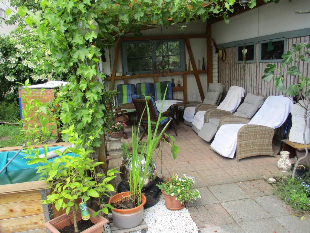an outdoor patio with couches and chairs and plants at Ferienwohnung Wendel in Erbach im Odenwald