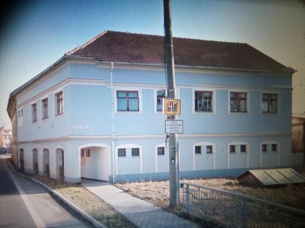 Penzion u Náhonu في Město Touškov: مبنى ازرق وابيض على جانب شارع