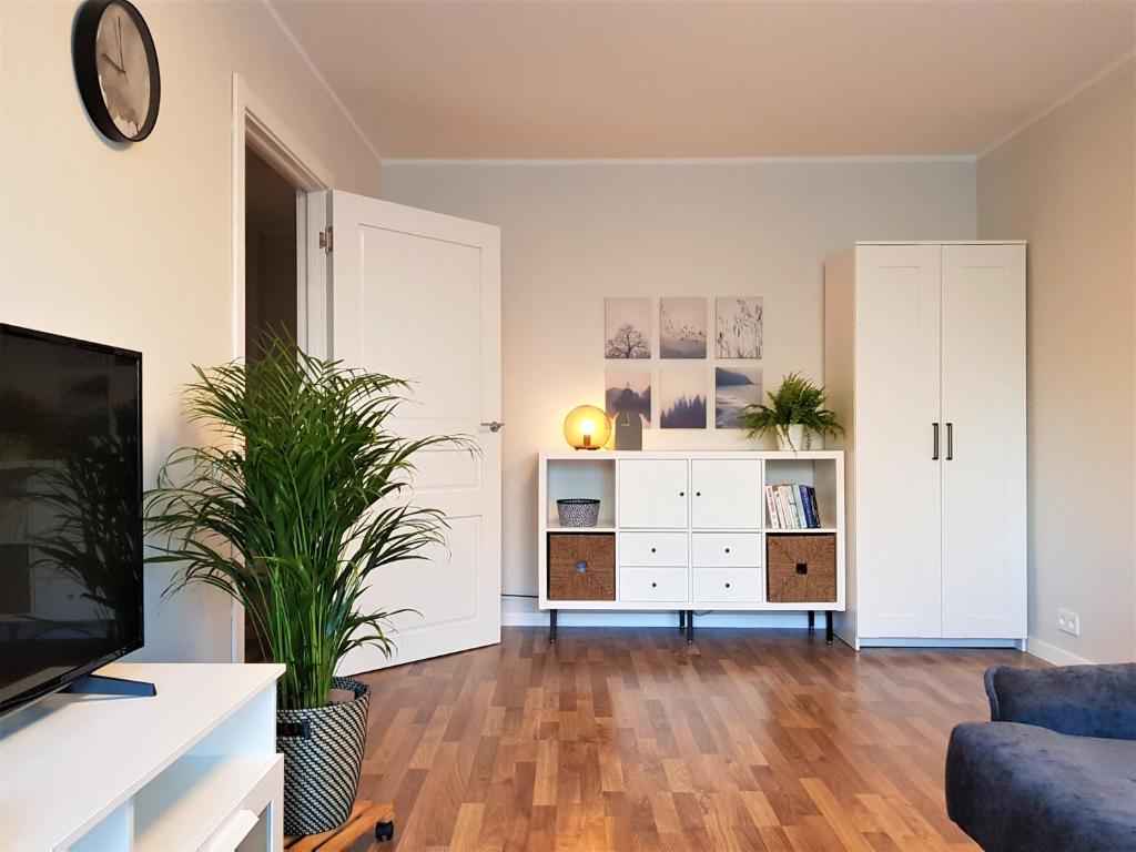 a living room with white cabinets and a tv at Modern city center apartment in Sigulda