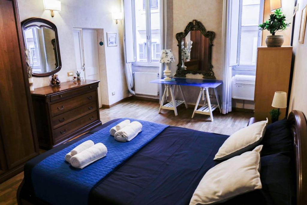 um quarto com uma cama azul com toalhas em Domus Titiana Amazing Apartment in Trastevere em Roma