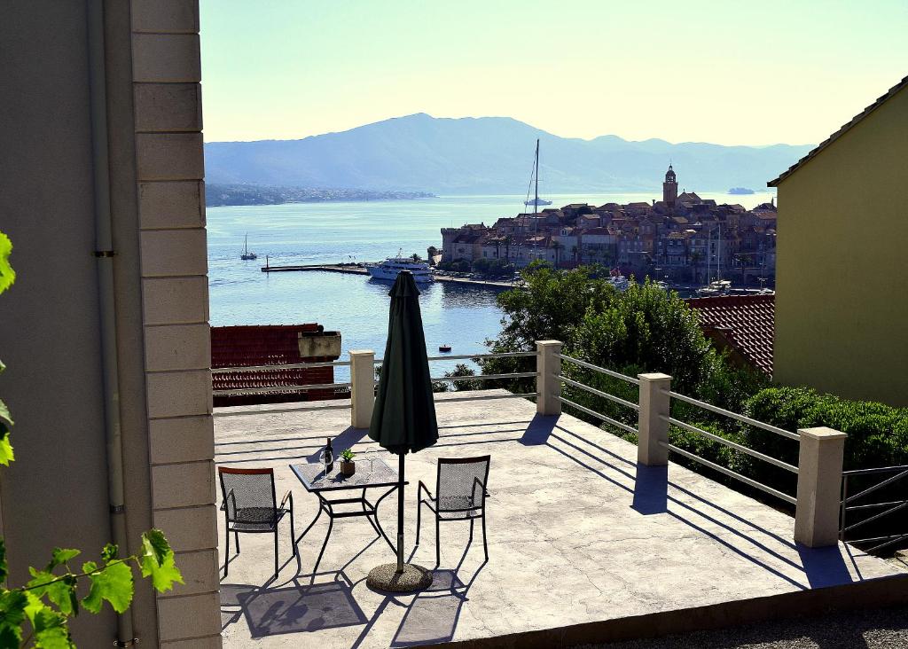 un patio con sillas, sombrilla y agua en Apartment Bellevue en Korčula