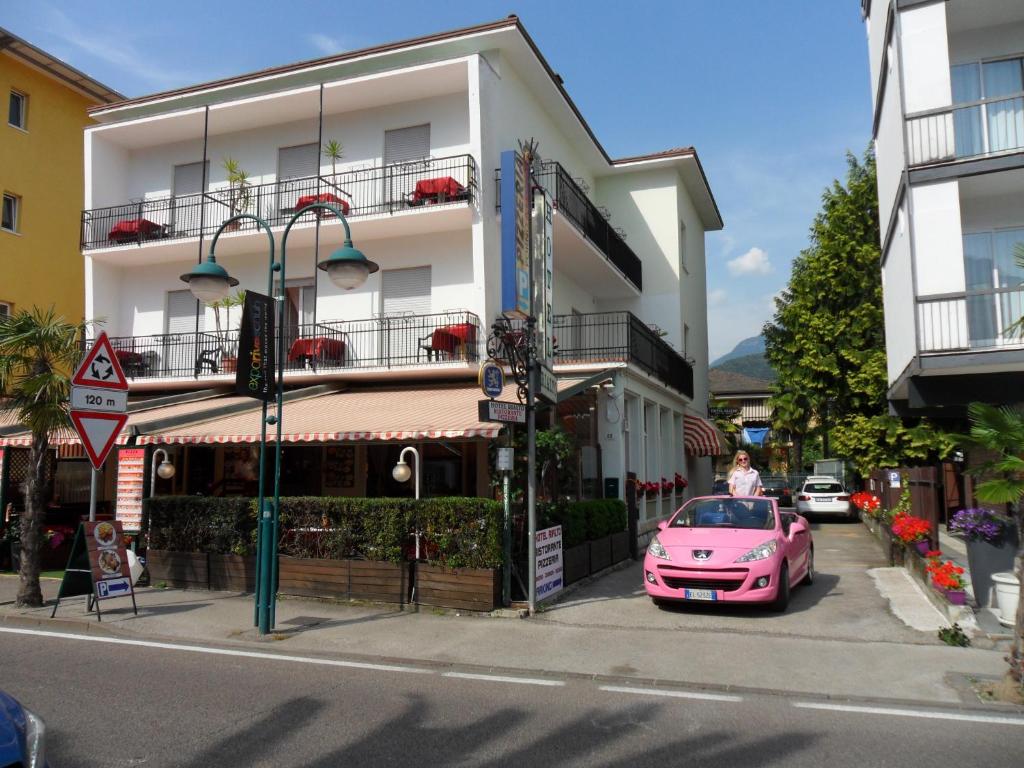 un coche rosa estacionado frente a un edificio en Hotel Rialto en Riva del Garda