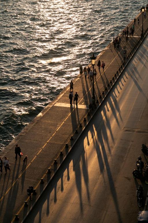 people walking on a pier next to the water at Daios Luxury Living in Thessaloniki