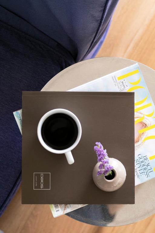 a cup of coffee and a vase on a table at Daios Luxury Living in Thessaloniki