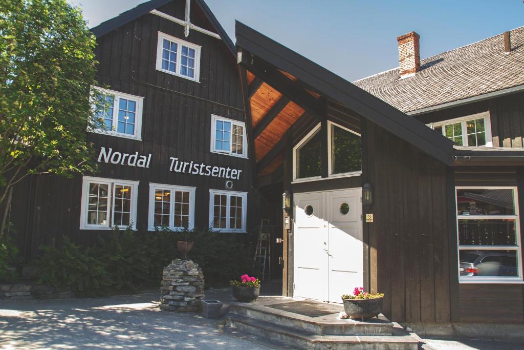 een schuur met een witte deur en een gebouw bij Nordal Turistsenter in Lom