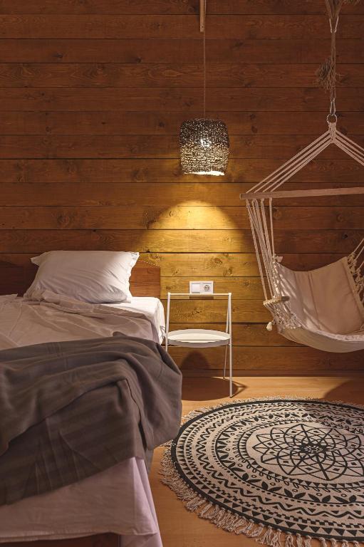 a bedroom with a hammock and a bed and a chair at The Monkee Studios in Sveti Vlas