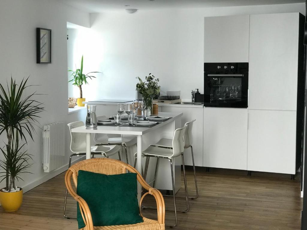 uma cozinha com armários brancos e uma mesa e cadeiras em Appartement au coeur du quartier historique em Vannes