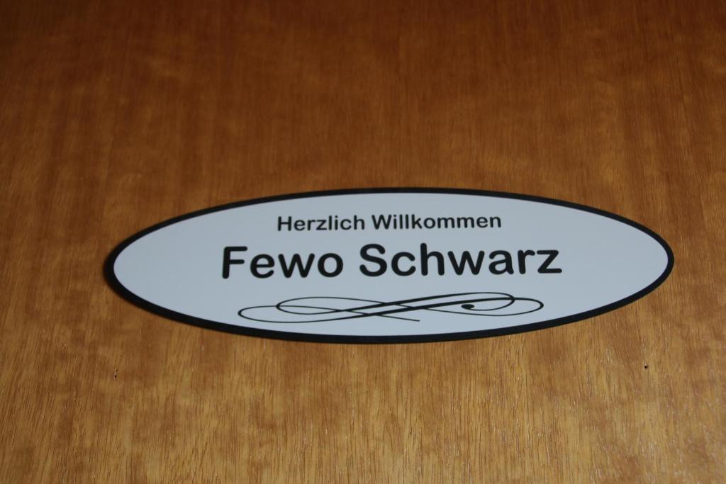 Znak z napisem "fevo schwartz" w obiekcie FeWo Schwarz w mieście Dornumersiel