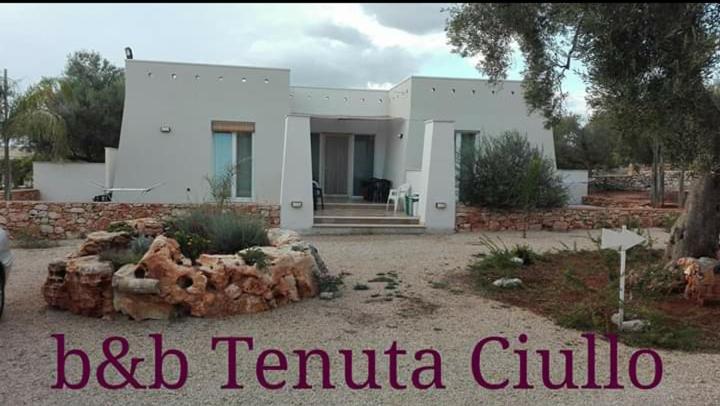 une grande maison blanche avec les mots bbc temula cuutic dans l'établissement Tenuta Ciullo, à Marina di Pescoluse