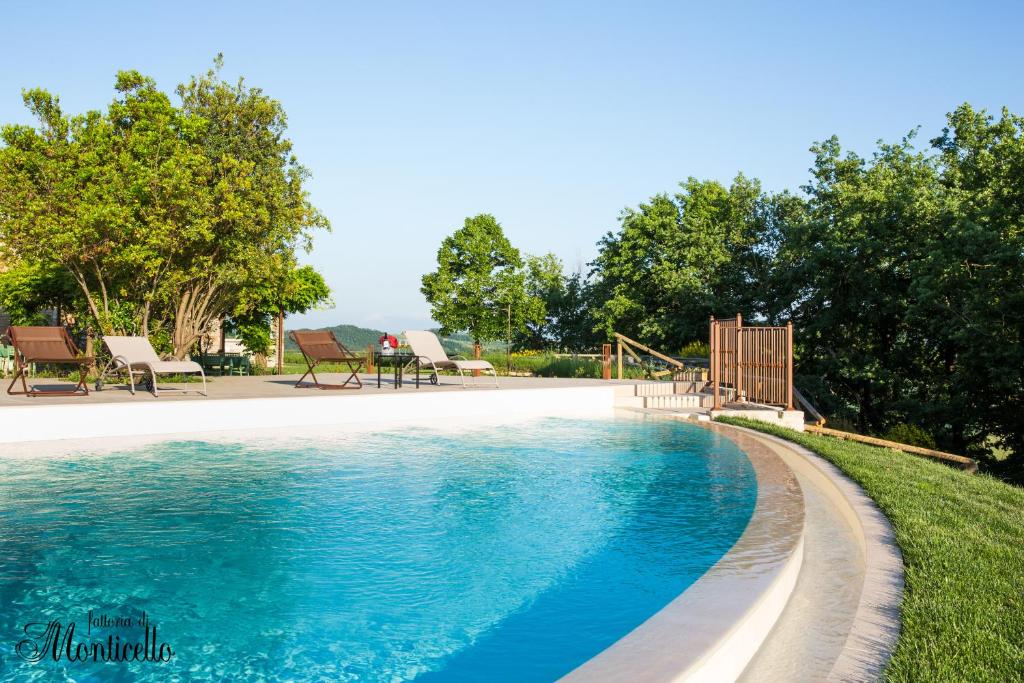 basen z błękitną wodą na dziedzińcu w obiekcie Agriturismo Fattoria di Monticello w mieście San Venanzo