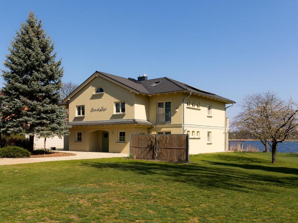 a large white house with a gate in the grass at Casa sul Lago in Werder