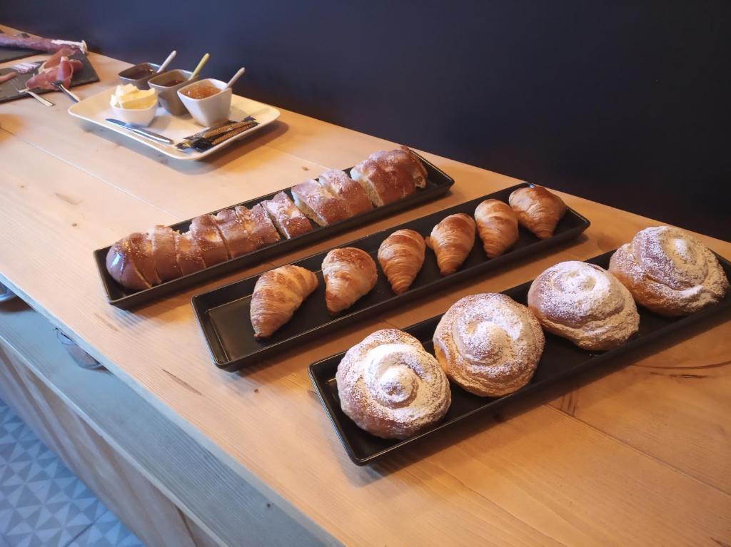 a table with several different types of pastries on at CAN MENCIÓ - Plaça Major in Santa Pau