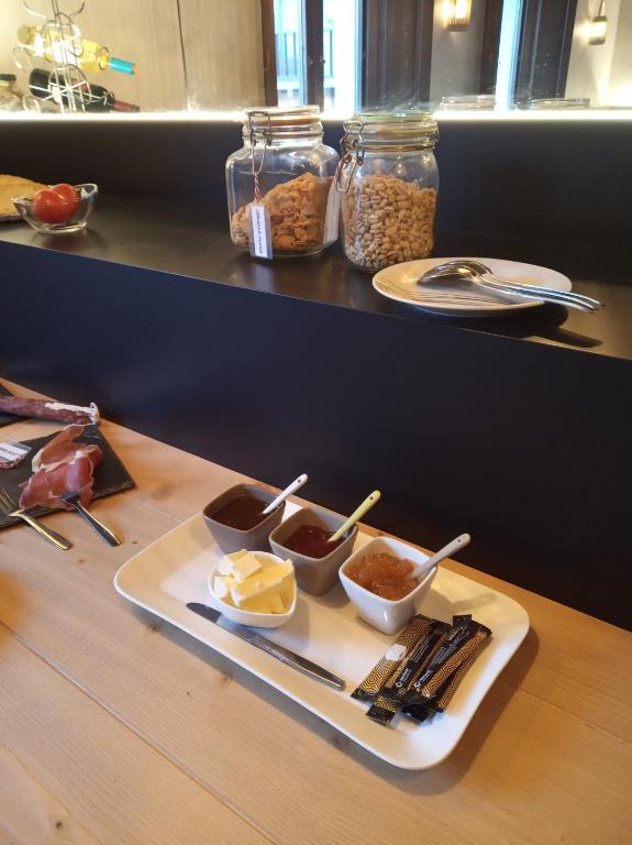 a tray of food on a table with condiments at CAN MENCIÓ - Plaça Major in Santa Pau