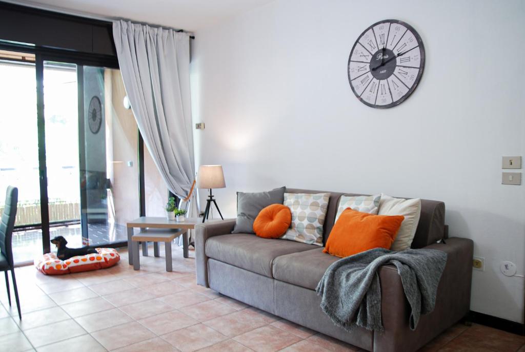 a living room with a couch and a clock on the wall at Home & Pet - Fiori in Basiglio