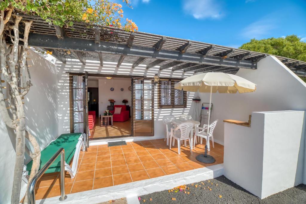 馬西尼古蒂的住宿－Ona Las Casitas，庭院配有遮阳伞和桌椅。