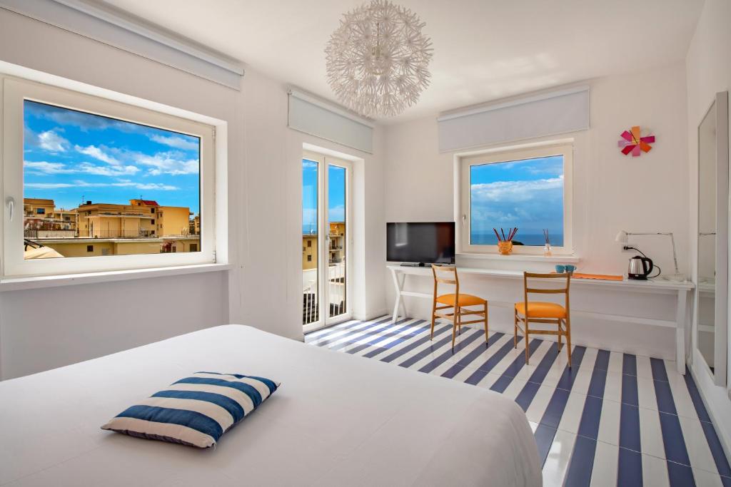 een slaapkamer met een bed en een tafel met een bureau bij 3 Suites View in Sorrento