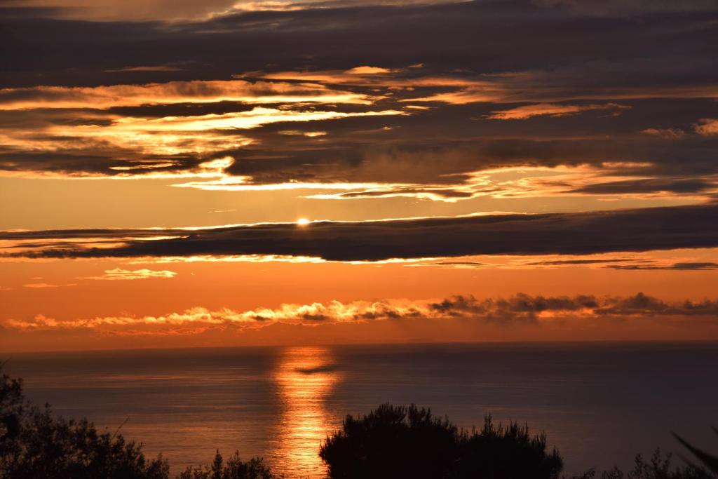 a sunset over the ocean with the sun setting at Oasi di Villa Damecuta in Anacapri