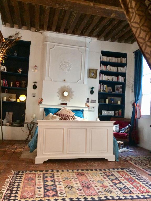 une chambre avec un grand lit blanc dans une pièce dans l'établissement Le Boudoir d'artiste, à Semur-en-Auxois