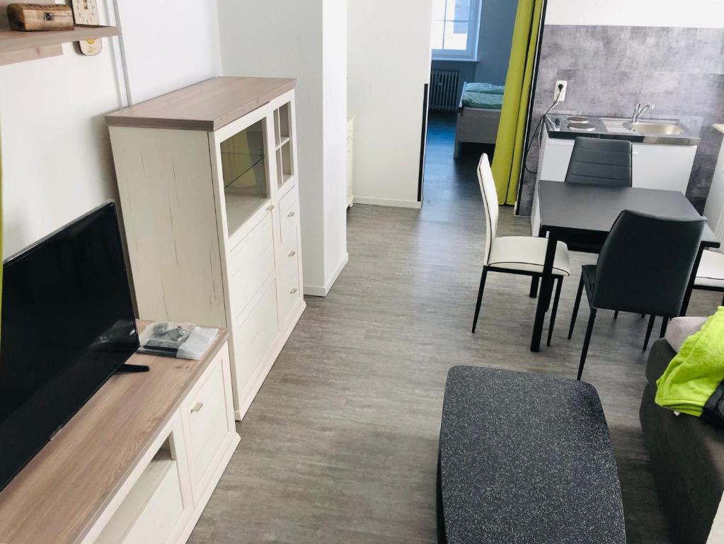een woonkamer met een keuken en een tafel en stoelen bij City Apartments Ebern in Ebern