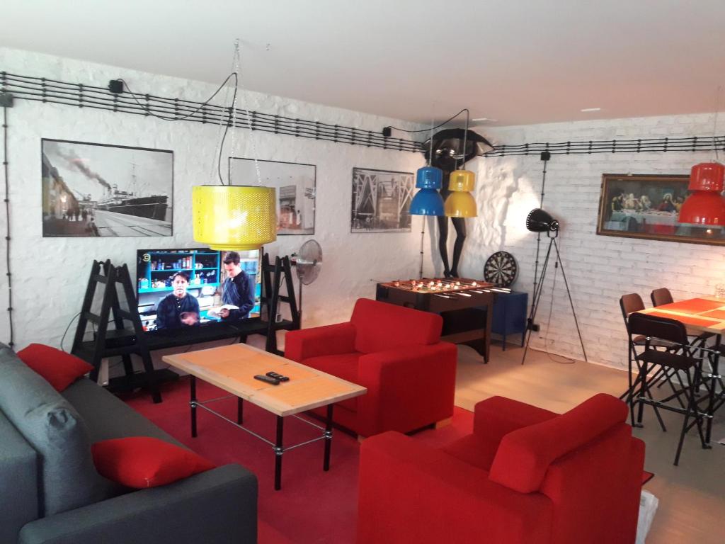 グディニャにあるCOZY CENTER :-)のリビングルーム(赤い椅子、テレビ付)