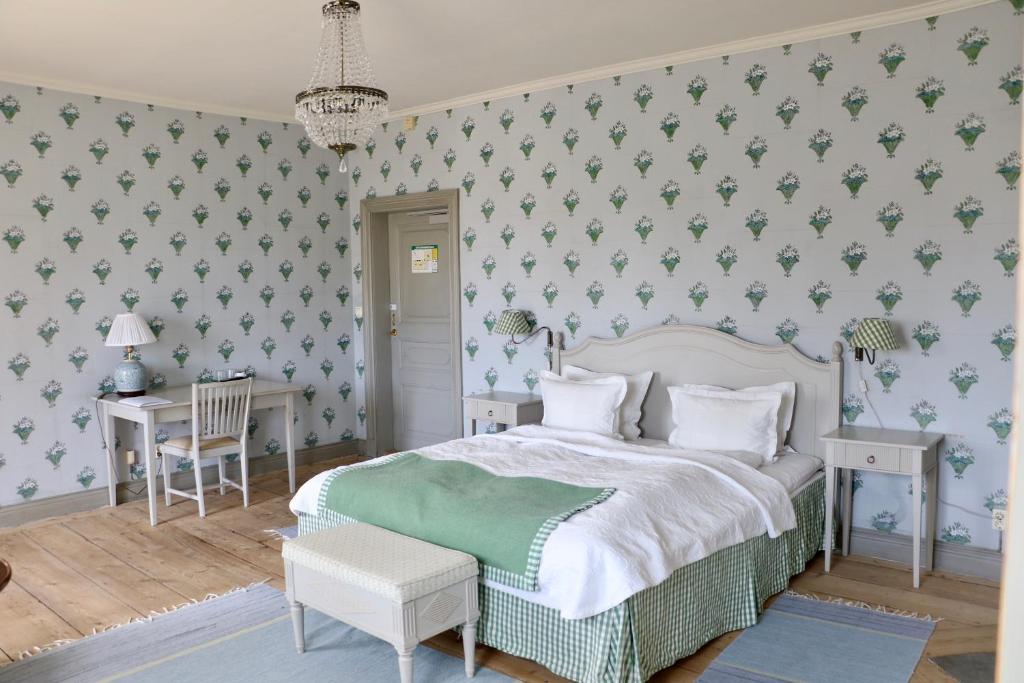 a bedroom with a bed and a table with a desk at Thottska Villan in Strömsholm