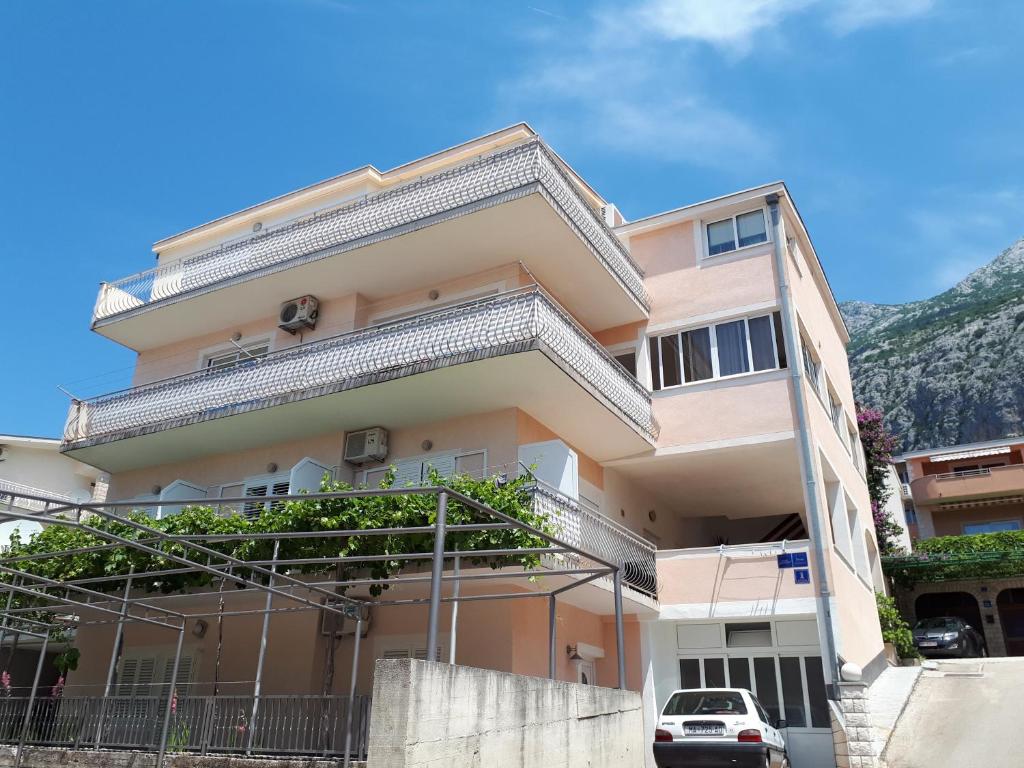 a building in front of a mountain at Apartments Veronika in Makarska