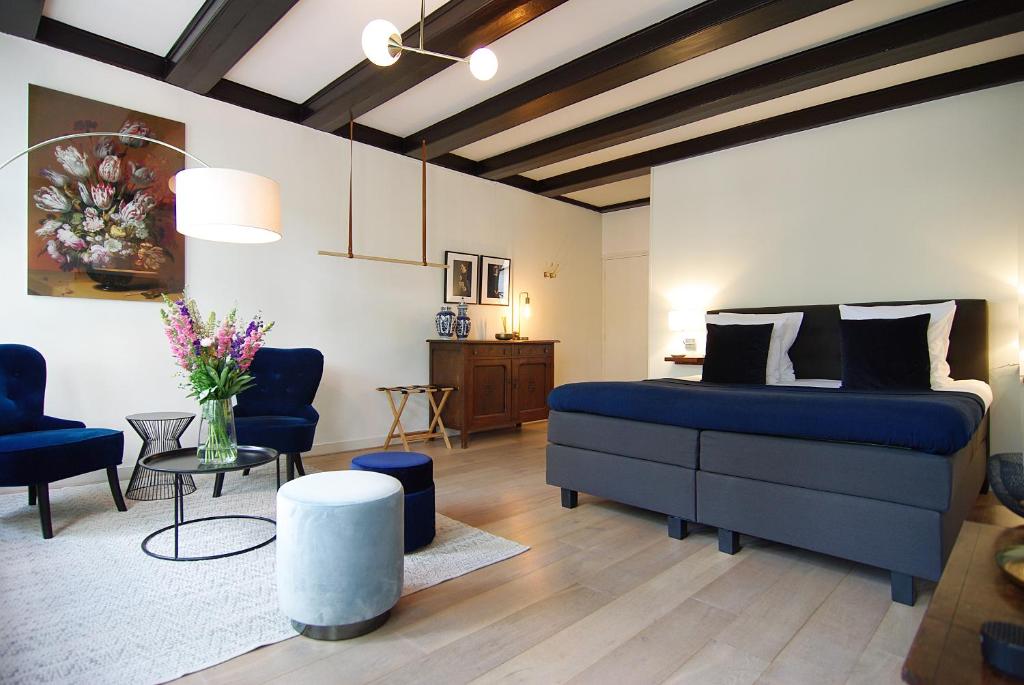 a bedroom with a blue bed and a living room at 1637: Historic Canal View Suites in Amsterdam
