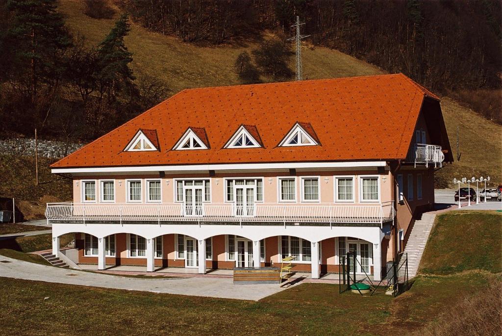 a large pink house with an orange roof at Rooms Hochkraut in Celje