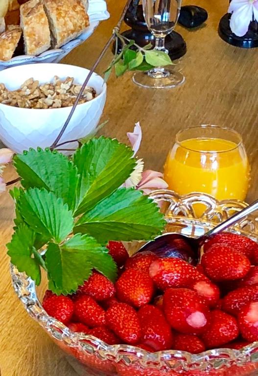 a bowl of strawberries and a bowl of orange juice at La Maison d&#39;Alice in Vézac