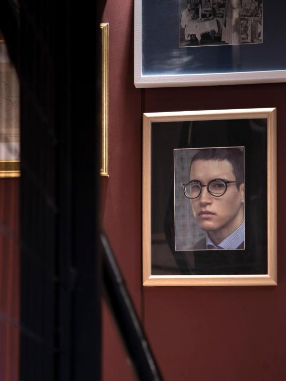 a picture of a man with glasses on a wall at The Pinnacle Athens in Athens