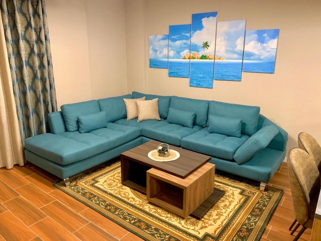 a living room with a blue couch and a coffee table at EKA Luxury Two-Bedroom Premium Apartment 2 in Durrës
