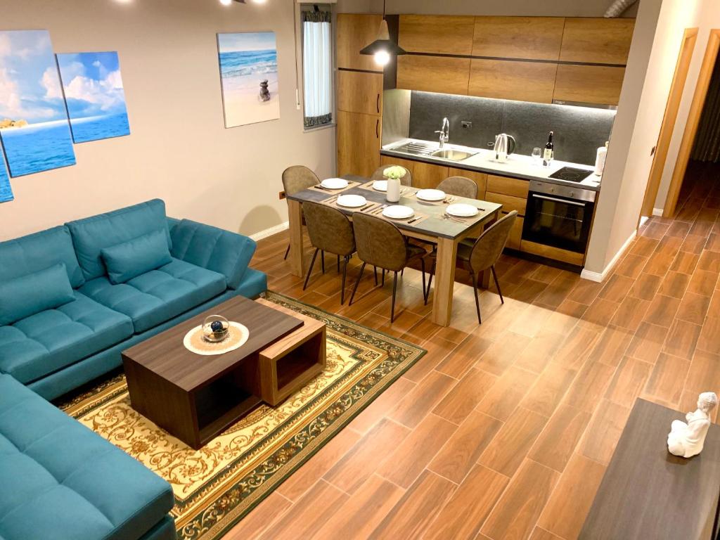a living room with a blue couch and a table at EKA Luxury Two-Bedroom Premium Apartment 2 in Durrës