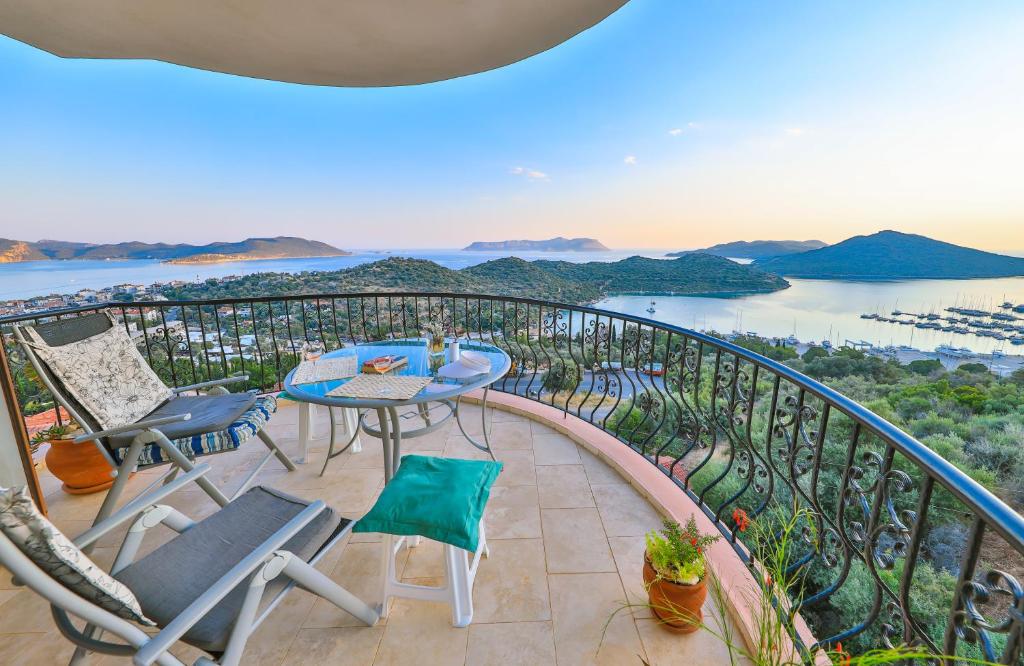 a balcony with chairs and tables and a view of the water at Nirvana Apartments in Kas