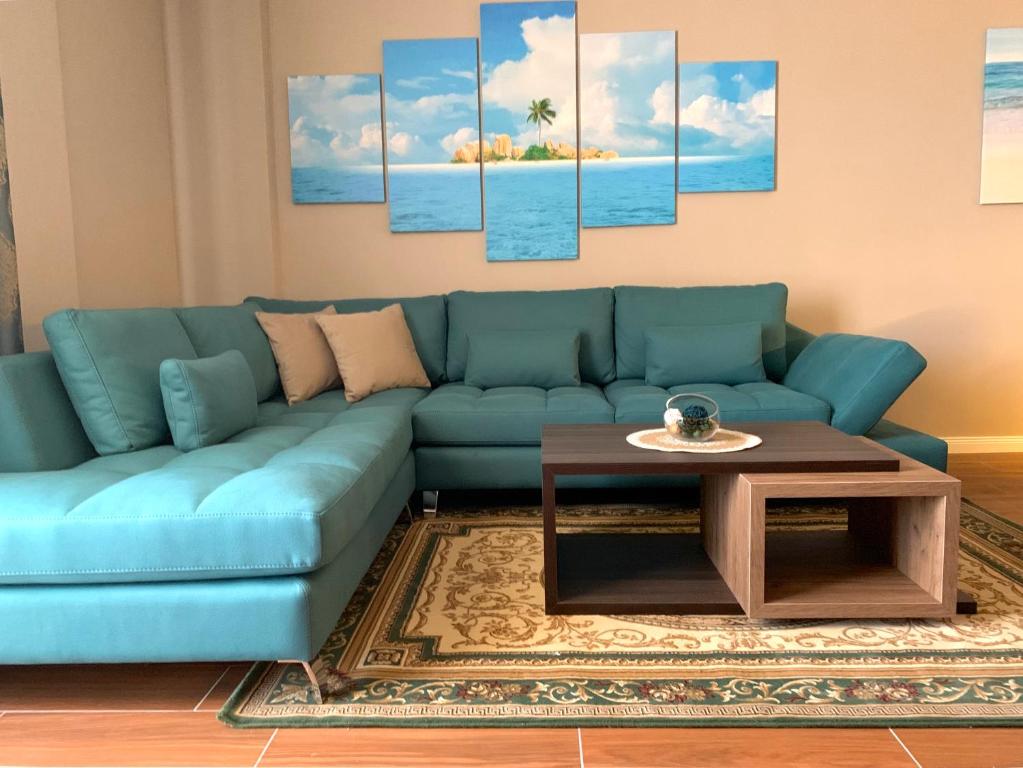 a living room with a blue couch and a table at EKA Luxury Two-Bedroom Premium Apartment 2 in Durrës