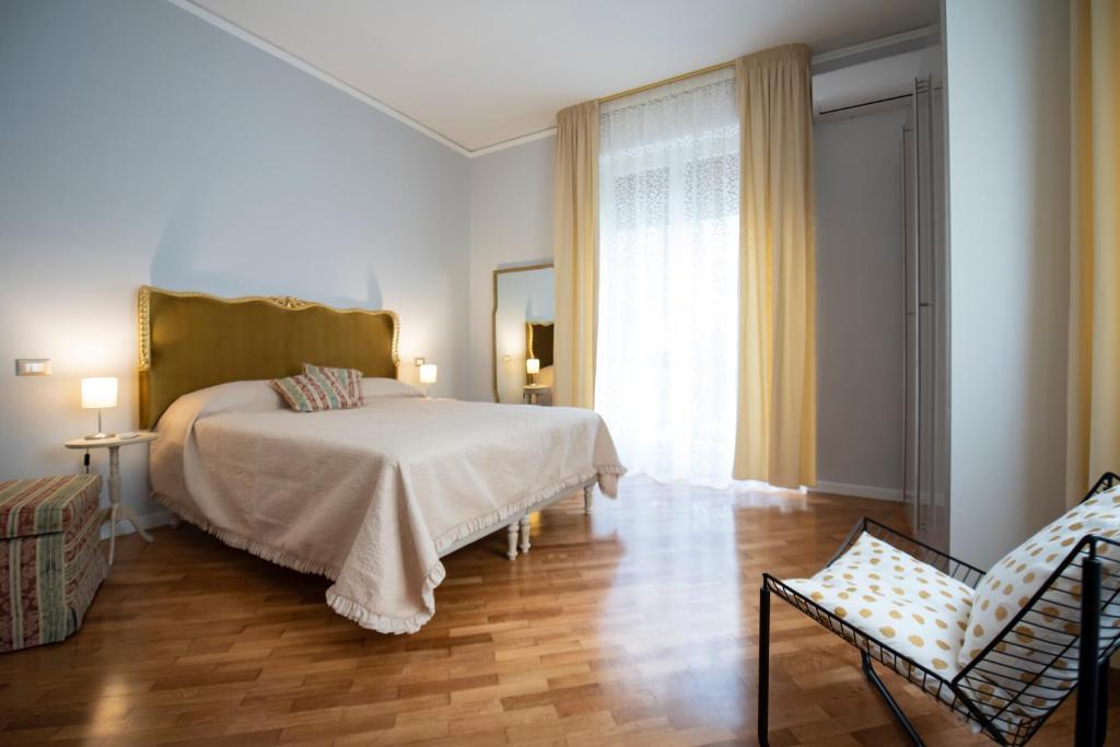 a bedroom with a bed and two chairs and a window at Laurus apartments in Trapani