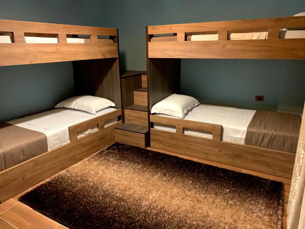 two wooden bunk beds in a room with a rug at EKA Luxury Two-Bedroom Premium Apartment 2 in Durrës