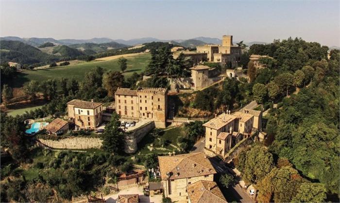 une vue aérienne sur un village avec des bâtiments et des arbres dans l'établissement Antico Borgo Di Tabiano Castello - Relais de Charme, à Tabiano