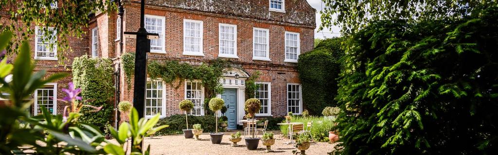 a large brick building with plants in front of it at Mangreen Country House in Norwich